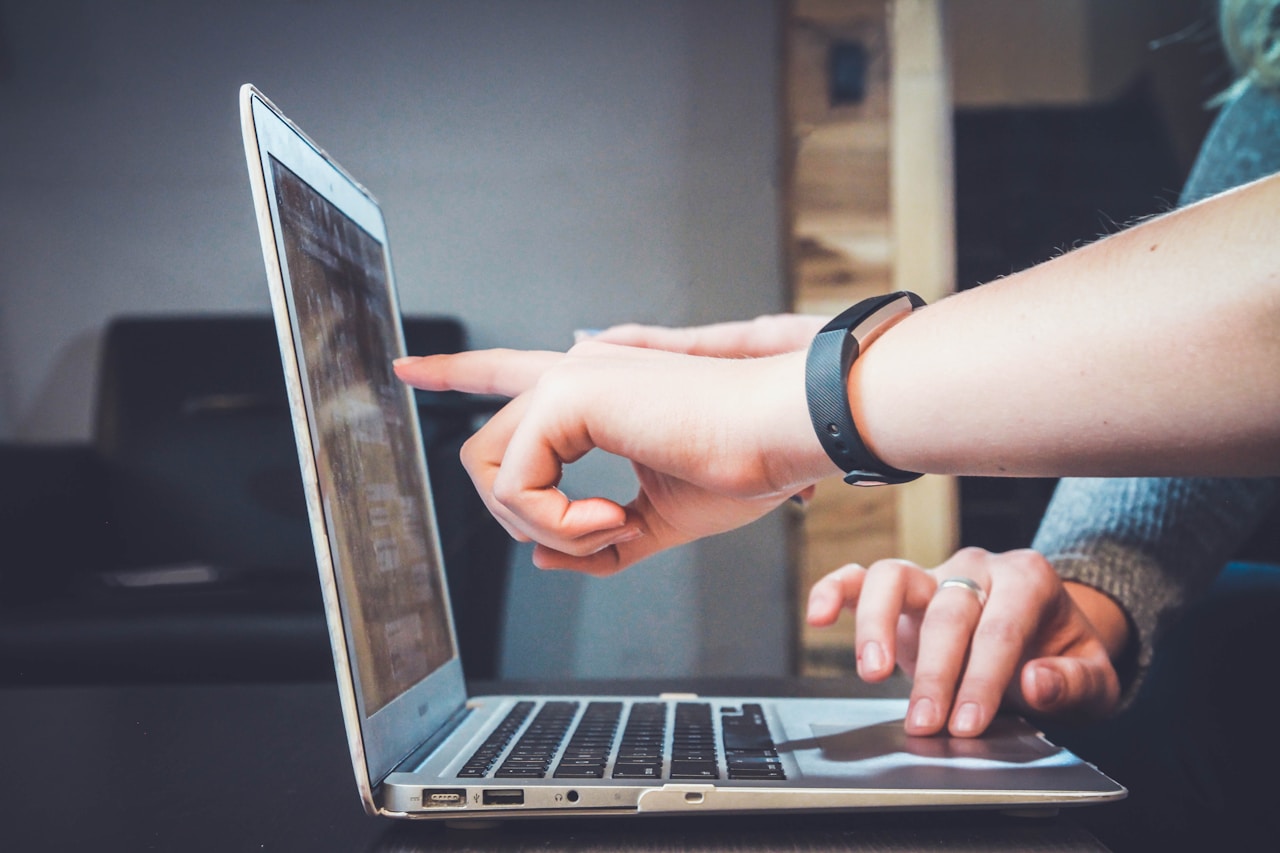 Person pointing something on a laptop